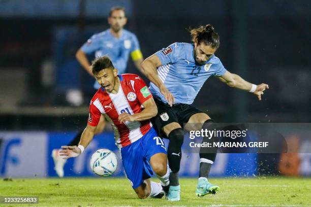 Uruguay's Martin Caceres and Paraguay's Oscar Romero vie for the ball during their South American qualification football match for the FIFA World Cup...