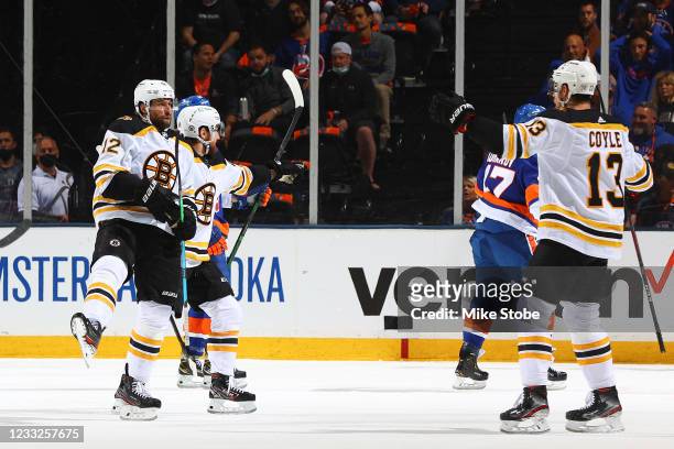 Craig Smith of the Boston Bruins is congratulated by his teammates after scoring a goal against the New York Islanders during the first period in...
