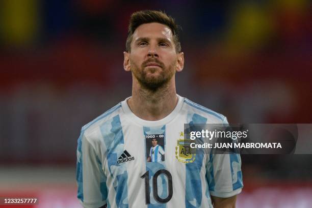 Argentina's Lionel Messi takes a picture of late Argentine football star Diego Armando Maradona on his jersey before the start of the South American...