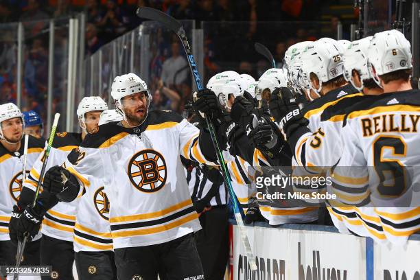 Craig Smith of the Boston Bruins is congratulated by his teammates after scoring a goal against the New York Islanders during the first period in...