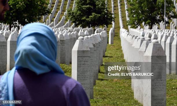 Picture taken on May 26 shows a woman standing near tombstones during her visit to the Memorial cemetery in Potocari-Srebrenica set up to honour the...