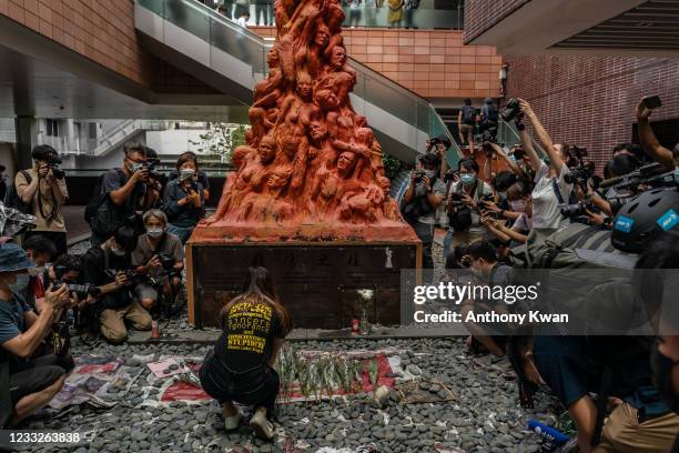 University students place flowers in front of the Pillar of Shame sculpture by Danish artist Jens Galschiot, to remember the victims of the Tiananmen...