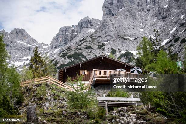 June 2021, Bavaria, Mittenwald: The Karwendel massif can be seen behind the Mittenwald hut. The refuge northwest below the Westliche Karwendelspitze...