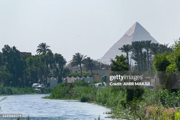 This picture taken on May 27, 2021 shows a view of Giza's Pyramid of Khafre from the Saqqara irrigation canal in the village of Saqqara, south of...