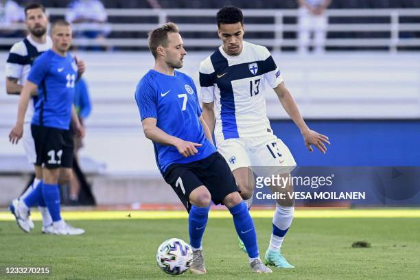 Sander Puri of Estonia and Finland's midfielder Pyry Soiri vie for the ball during the friendly football match Finalnd v Estonia in Helsinki on June...