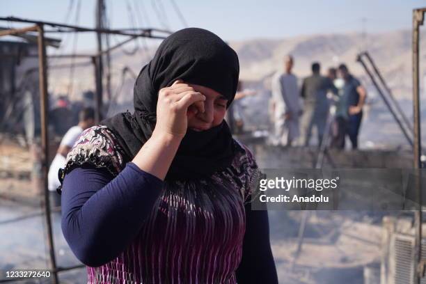 Woman reacts near burnt tents after a fire broke out at Sharia Camp, where Yazidi internal immigrants live, in Duhok, Iraq on June 04, 2021. About...