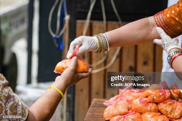 Hand of a woman receiving the free meal distributed by the community service center during the Prohibitory order due to the Second wave of the...