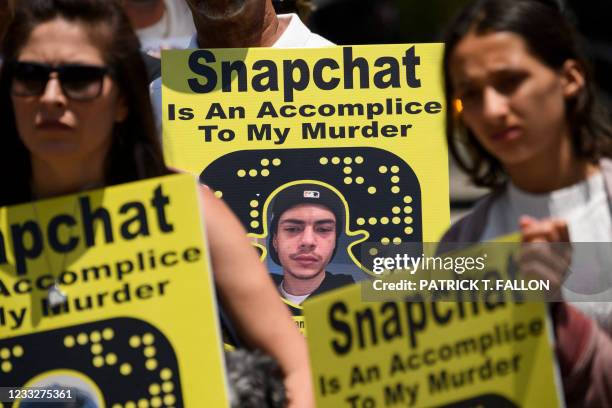 Family and friends of people who died after being poisoned by pills containing fentanyl carry signs as they protest near the Snap, Inc. Headquarters,...