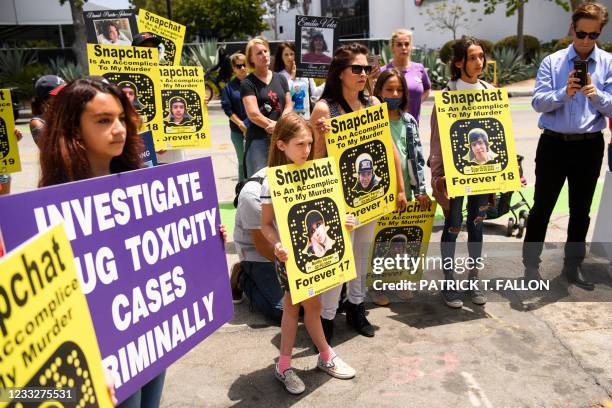 Family and friends of people who died after being poisoned by pills containing fentanyl carry signs as they protest near the Snap, Inc. Headquarters,...