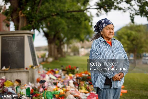 Kamloops Indian Residential School survivor Evelyn Camille poses for a pictures next to a makeshift memorial at the former Kamloops Indian...