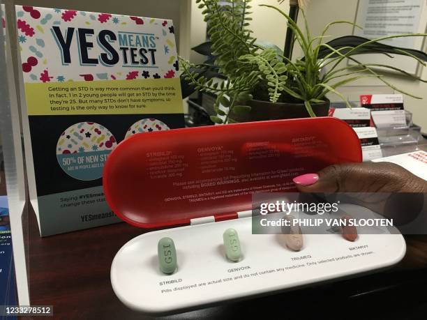 Dedra Spears Johnson, Heart to Hand Inc. Executive director and co-founder, holds a display sample of medications used to treat individuals living...