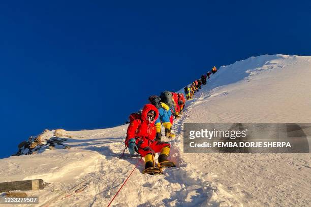 This photograph taken on May 12, 2021 shows mountaineers as they climb during their ascend to summit Mount Everest , in Nepal.