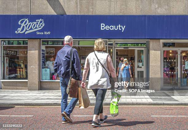 Couple walks towards Boots Pharmacy on Royal Avenue in Belfast.