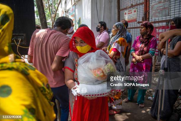 Sex worker carries free rations at G B Road, kamla market during the distribution. Under the programme 'Seva Hi Sangathan' BJP is distributing free...
