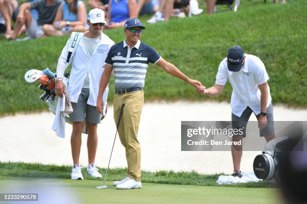 Rickie Fowler smiles while giving a ball to a caddie during the third round of the Memorial Tournament presented by Nationwide at Muirfield Village...