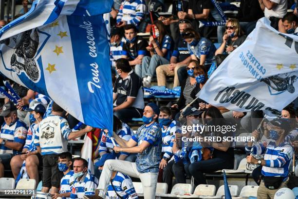 Castres' football fans hold flags in grandstand during the French Top14 rugby union match between Castres Olympique and RC Toulonnais at Stade Pierre...