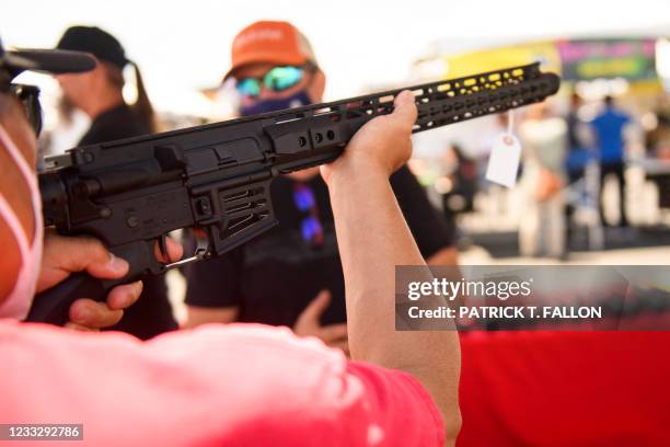 Customer holds an TPM Arms LLC California-legal featureless AR-15 style rifle displayed for sale at the company's booth at the Crossroads of the West...