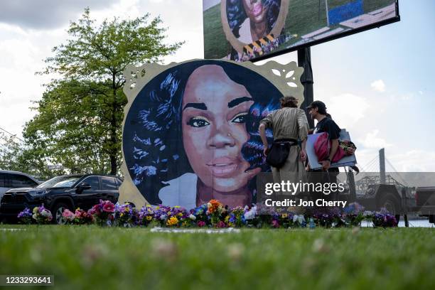 Protesters and volunteers prepare a Breonna Taylor art installation by laying posters and flowers before the "Praise in the Park" event at the Big...