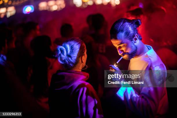 Man lights a cigarette during the Unum Festival at Rana e Hedhun beach on June 6, 2021 in Shengjin, Albania. International electronic musicians like...