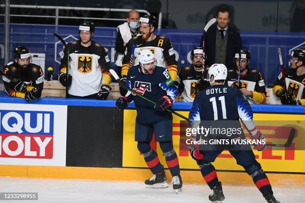 Defender Christian Wolanin and US' forward Brian Boyle celebrate the 1-0 as Germany's players look on from the sidelines during the IIHF Men's Ice...