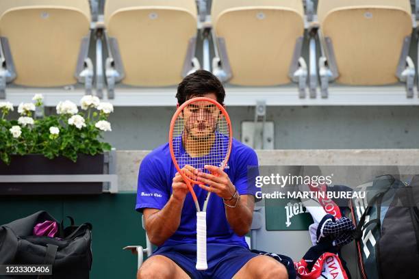 Chile's Christian Garin adjusts his racquet during a break during his men's singles fourth round tennis match against Russia's Daniil Medvedev on Day...