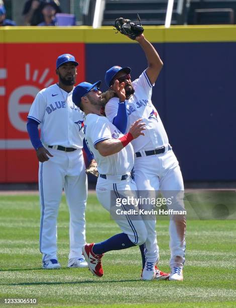 Marcus Semien of the Toronto Blue Jays makes a catch on a fly by Taylor Jones of the Houston Astros as Randal Grichuk runs into him during the...