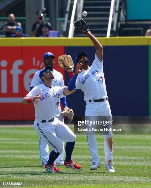 Marcus Semien of the Toronto Blue Jays makes a catch on a fly by Taylor Jones of the Houston Astros as Randal Grichuk runs into him during the...