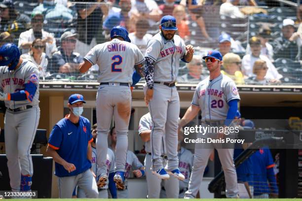 Dominic Smith of the New York Mets is congratulated by Jonathan Villar after hitting a solo home run during the fourth inning of a baseball game...