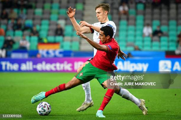Portugals Tiago Tomas fights for the ball with Germanys Nico Schlotterbeck during the 2021 UEFA European Under-21 Championship final football match...