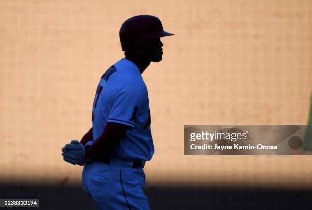 Shohei Ohtani of the Los Angeles Angels waits in the shadows during a pitching change in the ninth inning of the game against the Seattle Mariners at...