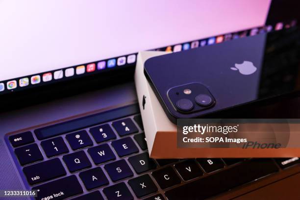 In this photo illustration, Apples iPhone 12 seen placed on a MacBook Pro.