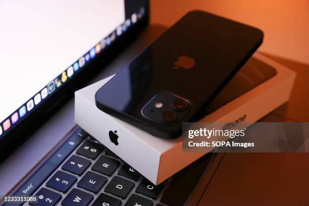 In this photo illustration, Apples iPhone 12 seen placed on a MacBook Pro.