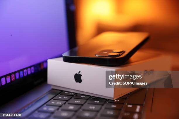 In this photo illustration, Apples iPhone 12 seen placed on a MacBook Pro.