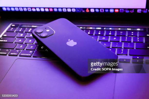 In this photo illustration, Apples iPhone 12 seen placed on a MacBook Pro.