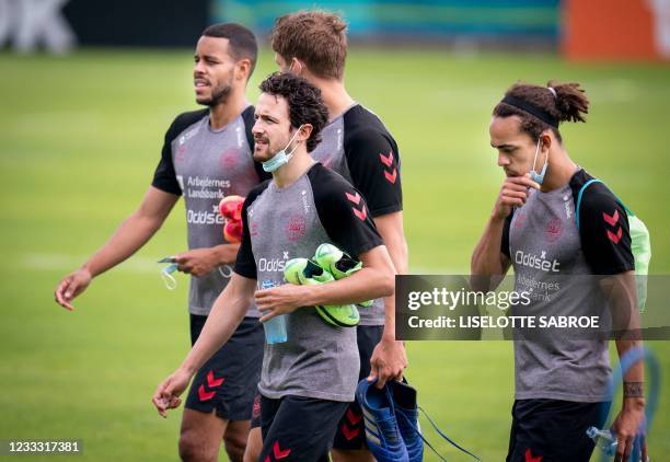 Denmark's midfielder Thomas Delaney, Mathias Joergensen and Denmark's midfielder Yussuf Poulsen walk over the pitch during a training session in...