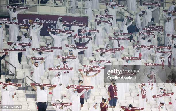 Qatari fans hold up a scarves during FIFA World Cup 2022 Qualifiers second round Group E match between Oman and Qatar at Jassim Bin Hamad Stadium in...