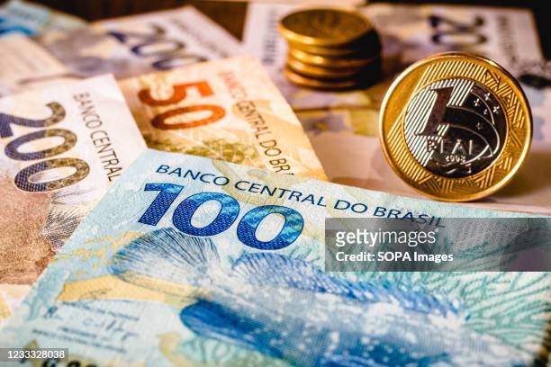 In this photo illustration the real coins are placed on top of Brazilian banknotes.