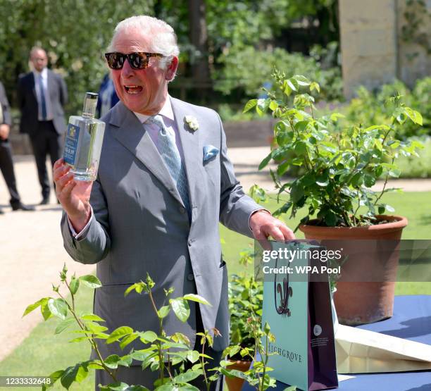 Prince Charles, Prince of Wales swaps a bottle of his Highgrove Gin with a bottle of Oxford Physic Gin which was presented to him as he visits the...