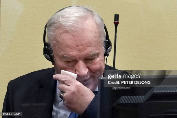 Ex-Bosnian Serb military chief Ratko Mladic wipes his face as he sits in the defendant box during the earing of the final verdict on appeal against...