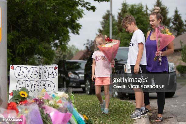 Families pay their respects on June 8 at a makeshift memorial near the site where a man driving a pickup truck struck and killed four members of a...