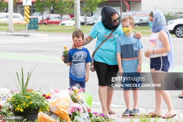 Families pay their respects on June 8 at a makeshift memorial near the site where a man driving a pickup truck struck and killed four members of a...