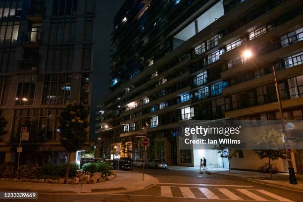 People walk by condo towers in the West Queen West neighborhood on June 7, 2021 in Toronto, Canada. After entering lockdown in early April amid a...