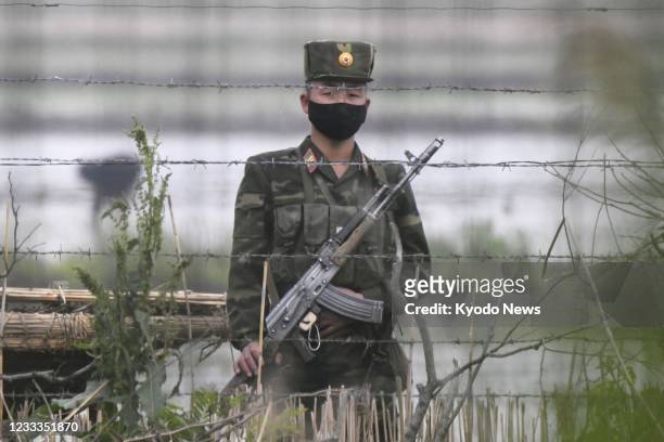 Photo taken from the Chinese border city of Dandong on June 6 shows a North Korean soldier patrolling on Hwanggumpyong Island in the Yalu River.