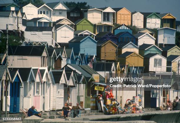 Beach huts and shopfronts along the seafront at Clacton-on-Sea in Essex, circa June 1988.