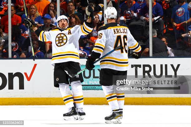 Brad Marchand of the Boston Bruins is congratulated by David Krejci after scoring a goal against the New York Islanders during the first period in...