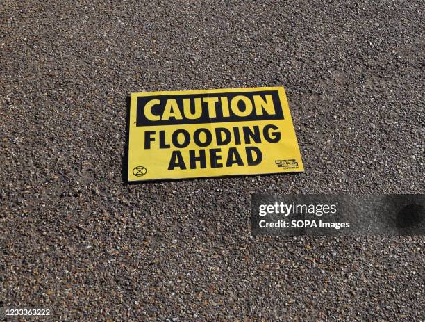 Caution: Flooding Ahead placard seen during the G7 protest. Extinction Rebellion activists gathered outside Tate Modern as part of the wider G7...