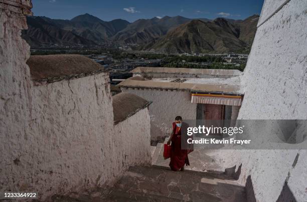 Tibetan Buddhist monk walks up the stairs in the Potala Palace, a UNESCO heritage site, during a government organized visit for journalists on June...