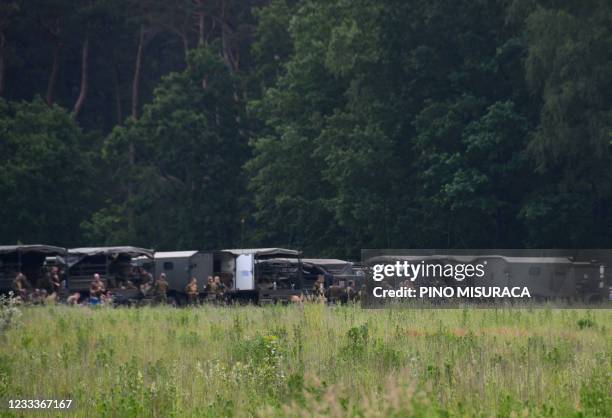 Army vehicles and soldiers are pictured at Nationaal Park Hoge Kempen in Dilsen-Stokkem on June 10, 2021 as researches are still underway for Jurgen...