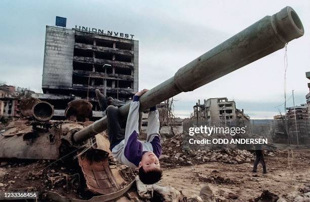 Young boy plays 22 April 1996 on a tank in the Sarajevo neighbourhood of Grbavica. AFP PHOTO ODD ANDERSEN