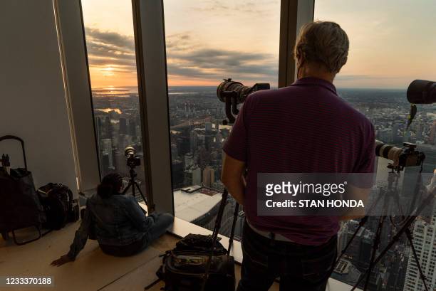 Members of the Amateur Astronomers Association of New York watch as the sun rises partially eclipsed on June 10 from Summit One Vanderbilt, a high...